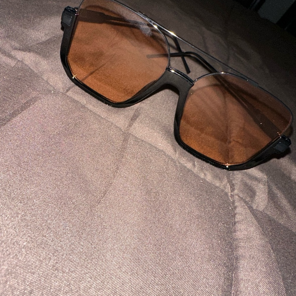 Two pair of sunglasses and one pair of non prescription eye glasses.